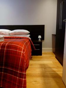 伦敦Amara & Nomad 2 Chiswick West London的一间卧室配有一张带红色铺面毯子的床 更多27张照片