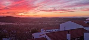 a sunset over a city with buildings and mountains at Casa Rural Abuela Remedios in Segura de León