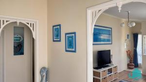 un soggiorno con TV e arco di Bromyard Cottage a Swansea