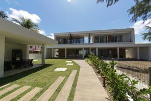 uma vista exterior de uma casa com um quintal em Casa Boutique Pontal da Ilha - 5 suítes - 14 pessoas em Itamaracá
