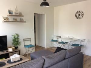 a living room with a couch and a table with chairs at Le sablon 50m plage et centre ville 1 a 4 personnes in Saint Malo