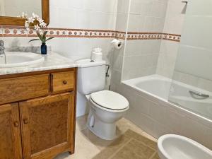 a bathroom with a toilet and a sink and a tub at Penthouse Apartment Orihuela Costa in Orihuela Costa +13 photos