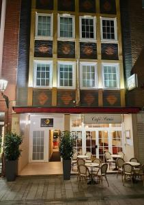 Un restaurante con mesas y sillas frente a un edificio. en The Soho Altstadt Relais, en Düsseldorf