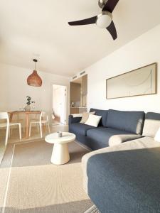 a living room with a blue couch and a table at Casa Estío - Renovated 1st line sea view apartment, pool access, AC - Calpe Costa Blanca in Ifach +13 photos