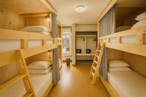 a room with four bunk beds with a ladder at Yellow House Niseko in Kutchan