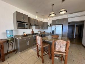 a kitchen with a table and chairs and a counter top at Oceanview Condo in Faro de Mita in Punta Mita