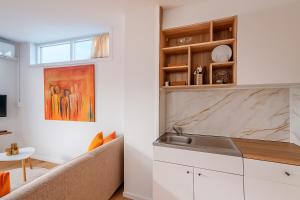 a kitchen with a couch and a sink in a room at De Strandgaper Egmond in Egmond aan den Hoef