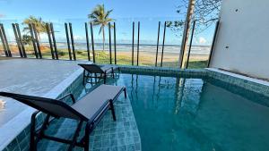 una piscina con sillas y vistas a la playa en Acqua Di Mare Pousada, en Itanhaém