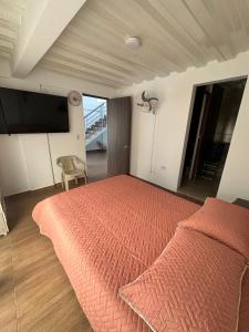a bedroom with a bed with a orange bedspread at La Casa de Oliva in Norcasia +3 photos