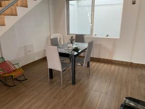 a dining room with a black table and white chairs at La Casa de Oliva in Norcasia
