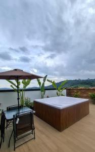 un letto e un tavolo e un ombrellone su un patio di Apartamento Central Santa Rosa de Cabal a Santa Rosa de Cabal