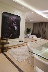 Una sala de estar con un televisor con un caballo en él. en فيلا مدينتى, en Madinaty
