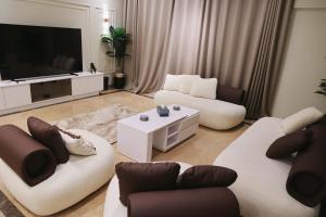 Una sala de estar con dos sofás y un televisor de pantalla plana. en فيلا مدينتى, en Madinaty