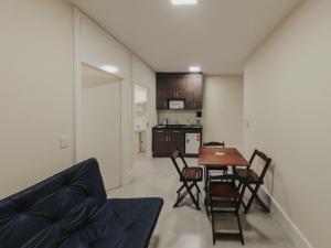 a living room and kitchen with a table and chairs at Recanto das Pedras Lodgin in Santa Maria do Erval