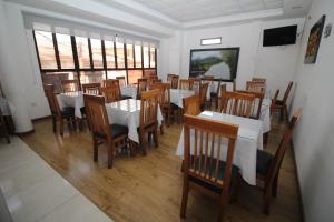 een restaurant met houten tafels en stoelen en ramen bij HOTEL NOGAL PLAZA in La Virginia