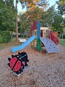 a playground with a slide in a park at Tiny House cosy pour une parenthèse nature in Marcilly-sur-Eure