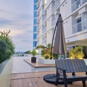 an umbrella sitting on a bench next to a building at Inspiria Condominium in Davao City