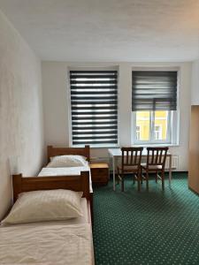 a bedroom with two beds and a table and chairs at Zahradní Apartments in Františkovy Lázně +19 photos