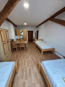 a room with two beds and a dining room at Zahradní Apartments in Františkovy Lázně