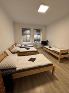 a room with three beds in it with windows at Zahradní Apartments in Františkovy Lázně
