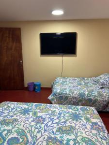 Una habitación con dos camas y un televisor de pantalla plana. en The Mountain Apto House, en Bogotá 2 fotos más