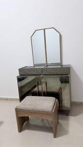 a chair and a table with a bench in a room at Fully Furnished Private Room in Abu Dhabi Intl