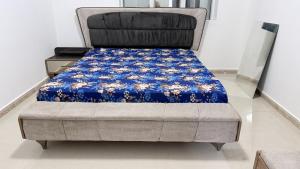 a bed in a room with a blue blanket on it at Fully Furnished Private Room in Abu Dhabi Intl