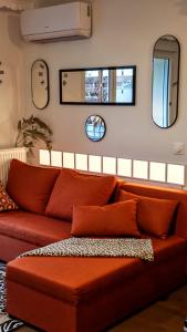 een rode bank in een woonkamer met spiegels bij Anton's Home in LʼHay-les-Roses