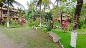un parco con panchine di fronte a un edificio di Pousada dos Comerciários Prainha de Mambucaba PARATY a Parati