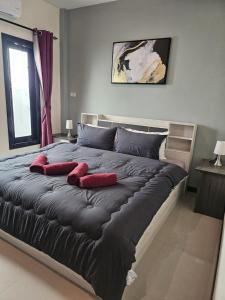 Ban Nong ChaengCute Villa 350m to Bang Tao Beach, sleeps up to 6的一间卧室配有一张大床和红色枕头