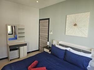 Ban Nong ChaengCute Villa 350m to Bang Tao Beach, sleeps up to 6的卧室里有一张蓝色的床和一面镜子