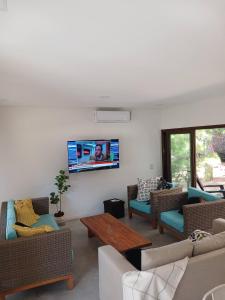 un soggiorno con divani e TV a parete di ecuestre53 a Pinamar