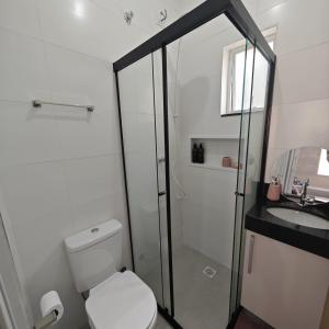 a bathroom with a shower and a toilet and a sink at Apartamento no Centro de Mongaguá, perto da praia! in Mongaguá