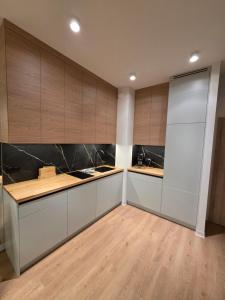 a kitchen with white cabinets and wooden counters at Omega Lake Family 1 in Olsztyn +2 photos