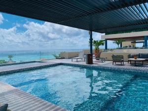 a swimming pool with a view of the ocean at 1 block from beach 2BR pool ocean view in Playa del Carmen