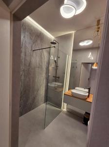a bathroom with a glass shower and a sink at Omega Lake Family 1 in Olsztyn