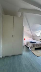 ein weißes Schlafzimmer mit einem Bett und einem weißen Schrank in der Unterkunft Tilff - Appartement cocooning in Esneux