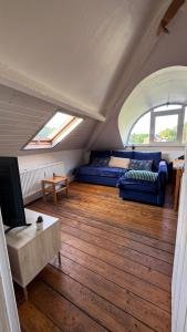 ein Wohnzimmer mit Sofa und Fernseher in der Unterkunft Tilff - Appartement cocooning in Esneux