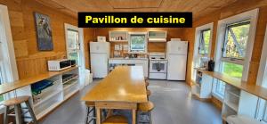 a kitchen with a wooden table in a tiny house at Centre nautique de l'Istorlet in Havre-Aubert