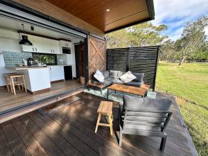 an outdoor living area with a table and chairs on a deck at Sol On Loten in Mitchells Island
