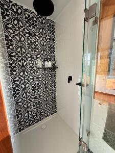 a shower stall with a black and white patterned wall at Sol On Loten in Mitchells Island +27 photos