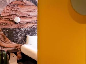 a bedroom with a bed and a painting on the wall at ibis styles Paris Montmartre Batignolles in Paris