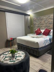 een slaapkamer met een groot bed met rode kussens bij Lake boutique hotel empire in Thohoyandou