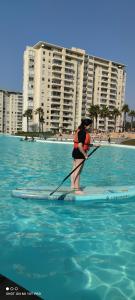a person on a paddle board in the water at Depto Laguna Vista Hermoso Comodo Familiar in Algarrobo