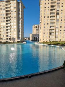 a large body of water between two tall buildings at Depto Laguna Vista Hermoso Comodo Familiar in Algarrobo