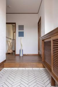 a living room with a wooden door and a white wall at Ito Orange Beach Villa - Ocean View & Private Onsen in Ito +106 photos