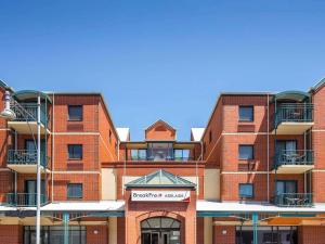 Un edificio de ladrillo rojo con un cartel. en BreakFree Adelaide, en Adelaida