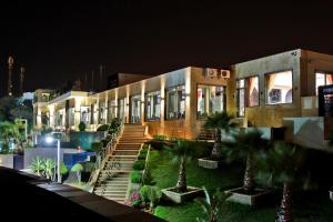 a building with palm trees in front of it at night at Mira Palace in Al Hoceïma