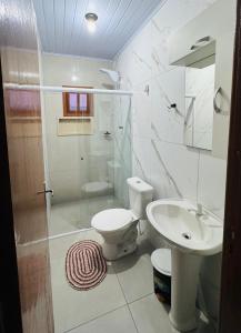 a bathroom with a shower and a toilet and a sink at kitnet 1 quarto in Arroio do Silva +8 photos