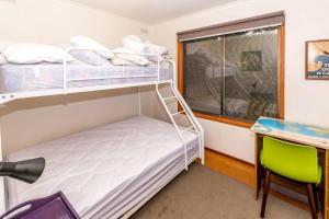 Sandy Pointにある18 Harbour View Sandy Pointの二段ベッド、デスク、窓が備わるドミトリールームのベッド1台分です。